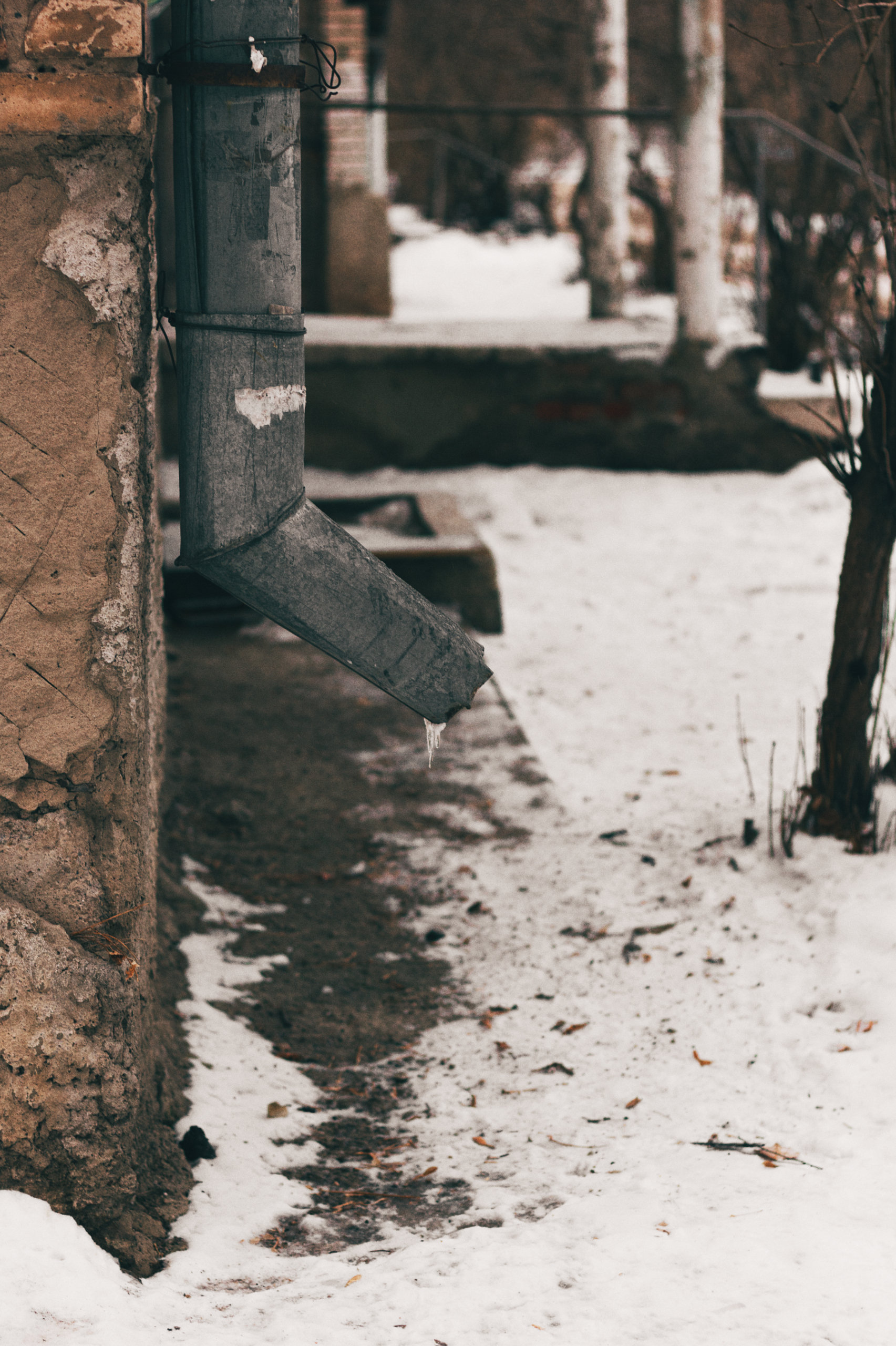 A downspout surrounded by winter snow