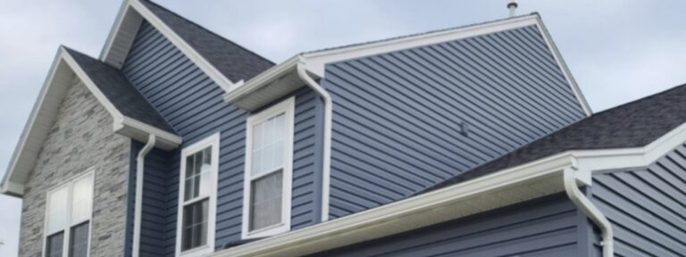 White gutters and downspouts on a blue-sided home.