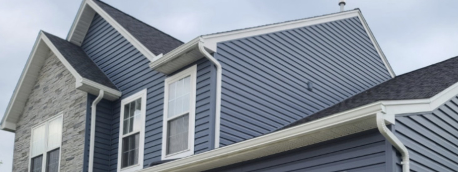 White gutters and downspouts on a blue-sided home.